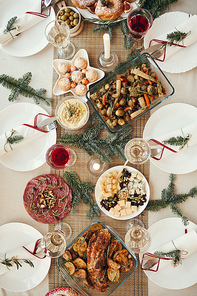 Top view background of beautiful dinner table decorated with fir branches set for Christmas banquet, copy space