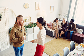 Side view portrait of elegant young woman talking to friends while hosting Christmas party at home, copy space