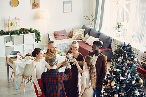 High angle view at group of elegant people enjoying Christmas party and drinking champagne in beautiful dining room, copy space