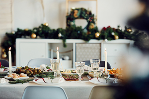 Background image of beautiful table setting for Christmas party with fir elegant candles and delicious homemade food, copy space