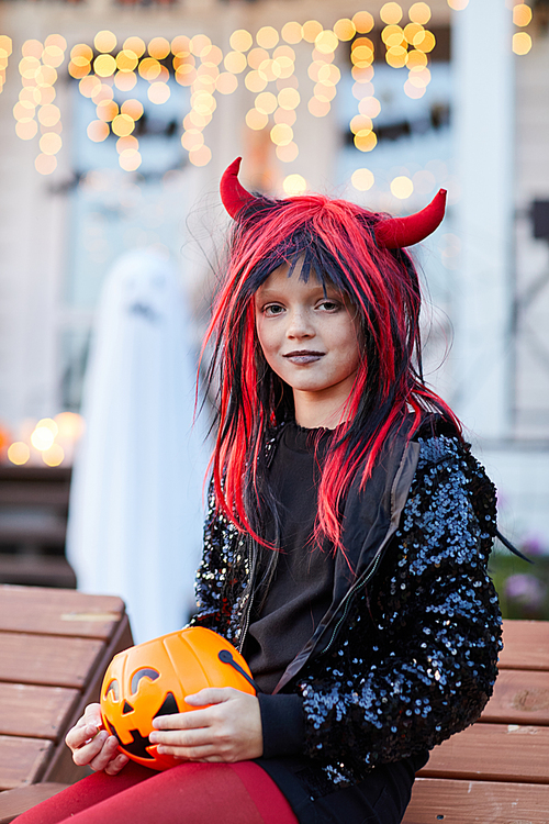 Portrait of smiling teenage girl wearing devil costume  on Halloween day, copy space