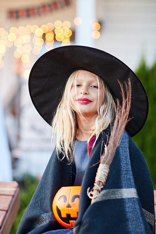 Portrait of smiling little girl wearing witch costume  on Halloween day, copy space