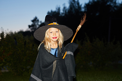 Waist up portrait of cute little witch  while standing in dark on Halloween, copy space