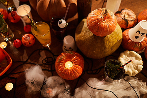Halloween background, top view of witches table with candles and pumpkins set for party in nightclub, copy space