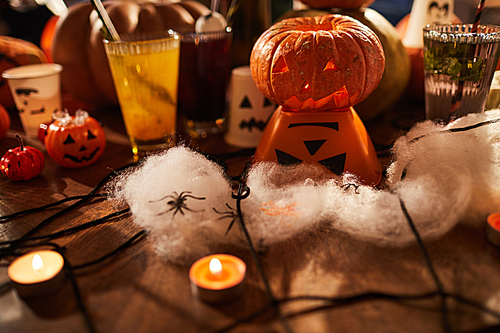 Halloween background, closeup of witches table with candles and pumpkins set for party in nightclub, copy space