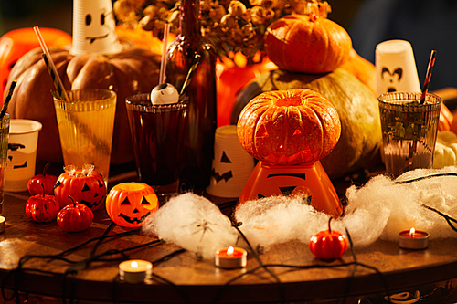 Background image of Halloween decorations, close up of pumpkins and candles set on table for party, copy space