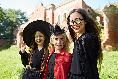 Waist up portrait of three happy little girl  while trick-o-treating on Halloween, copy space