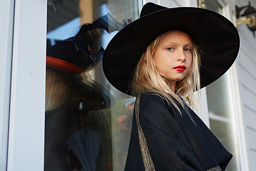 Side view portrait of cute little witch  while posing outdoors in Halloween season, copy space