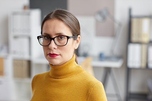 Close up portrait of adult woman wearing glasses and  while standing in architects office, copy space