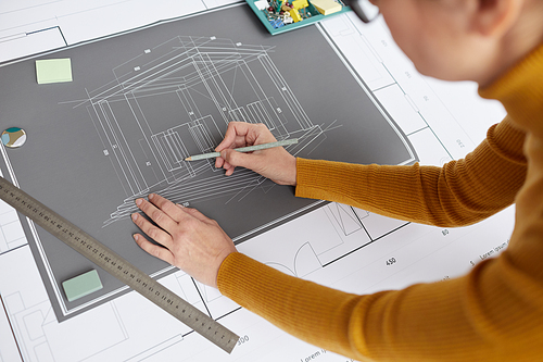 High angle shot of unrecognizable female architect drawing blueprints and plans while working at desk in office, copy space