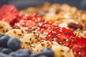 Extreme close up of delicious granola dessert decorated with fruit and berries with sesame seeds, healthy breakfast concept, copy space