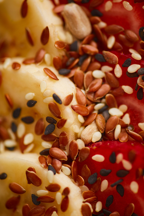 Vertical macro view of delicious granola dessert decorated with fruit and berries with sesame seeds, healthy breakfast concept, copy space