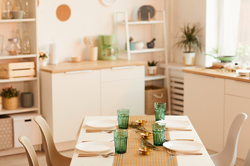 Warm toned image of minimal kitchen interior with served table in foreground, copy space