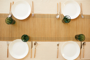 Above view background image of elegant table serving set for four guests in minimal kitchen interior, copy space
