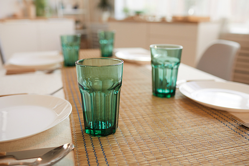 Close up of elegant table serving set for six guests in minimal kitchen interior, copy space