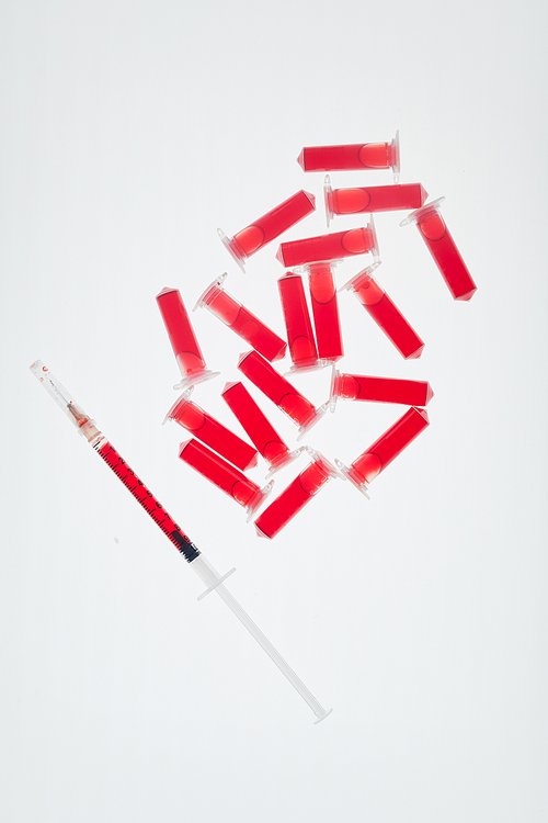 Top view background of syringe and blood samples on white table in medical laboratory, copy space