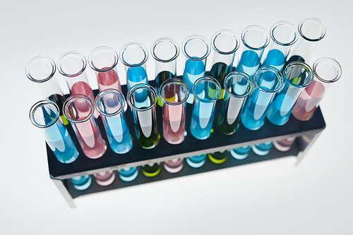 Above view background of test tubes with colored liquid on white table in medical laboratory, copy space