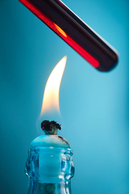 Extreme closeup of blood sample heating over gas fire in medical laboratory, background with copy space