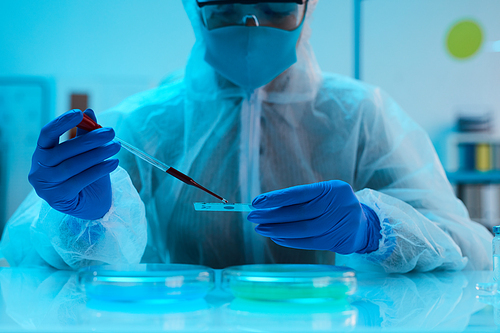 Portrait of scientist examining blood sample in medical laboratory while doing research, copy space