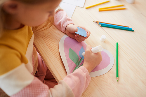 High angle view at cute little girl making handmade card for Mothers day, copy space