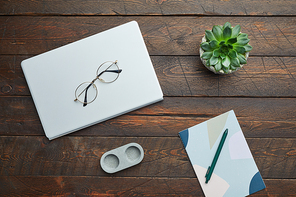 Minimal above view flat lay of business accessories glasses and succulent over wooden workplace background, copy space