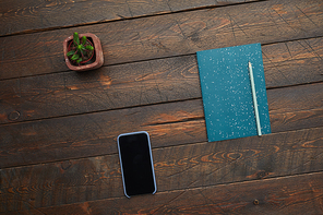 Minimal background image of smartphone and planner on textured wooden desk, top view, copy space