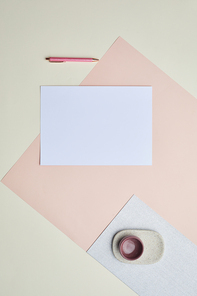 Minimal graphic composition of blank white paper on pastel-colored background, copy space