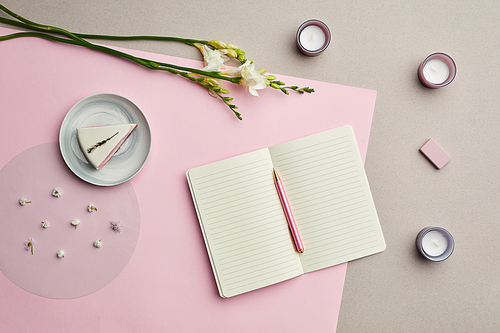 Minimal composition of blank planner over pink graphic background with floral decor, copy space