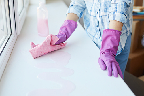Close up of unrecognizable woman washing windows during Spring cleaning, focus on female hands wearing pink gloves, copy space