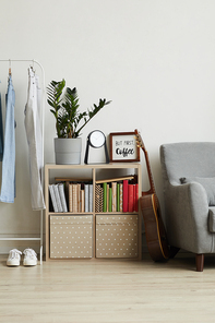 Vertical background of homey apartment interior, focus on small bookstand with decor items and plant, copy space