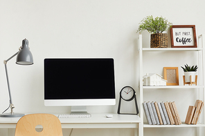 Background image of modern computer on desk against white wall in home office interior, copy space above