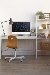 Vertical background image of contemporary home office workplace with wooden chair and PC lit by warm lamp light, copy space