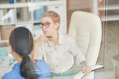 Shocked businesswoman talking to colleague in office, copy space