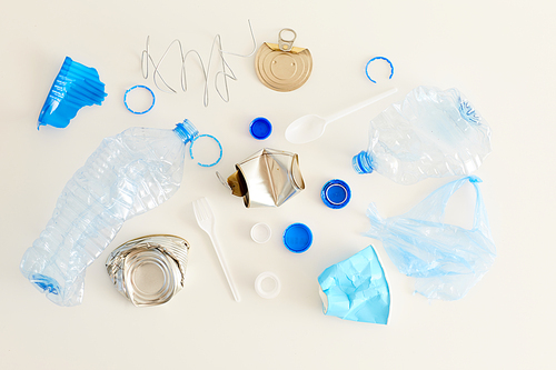 Above view of various trash items laid in minimal composition on white background, waste sorting and recycling concept, copy space