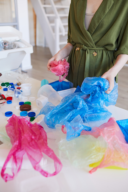 Mid section portrait of modern woman sorting plastic waste at home before recycling, copy space
