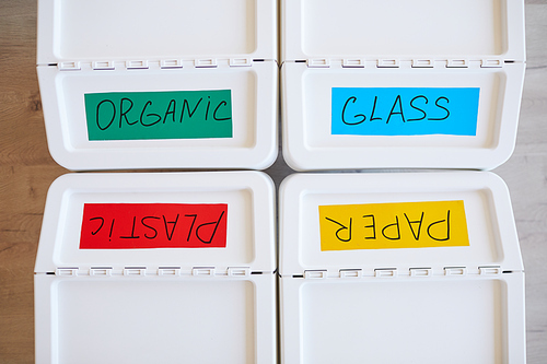 Top view background image of four plastic bins labeled for storage and sorting waste at home, copy space