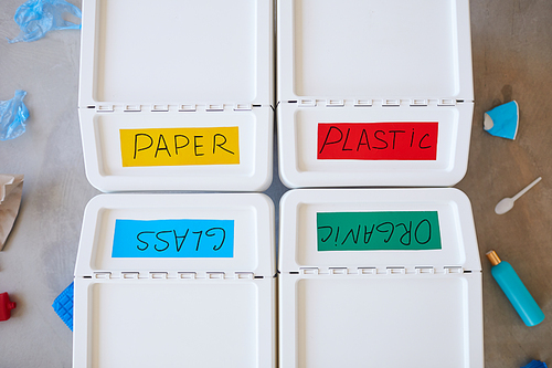Above view background of four plastic bins labeled for storage and sorting waste at home, copy space
