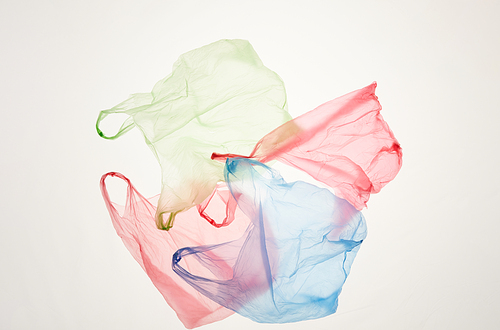 Top view background of discarded plastic bags on backlit white background, copy space