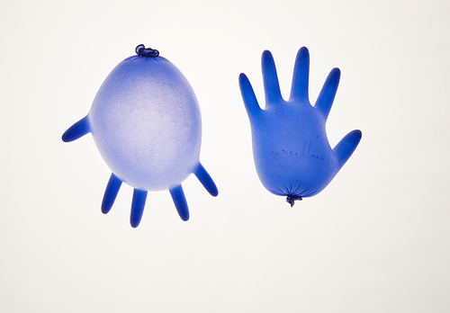 Top view at minimal composition of two medical rubber gloves laid over white background, copy space