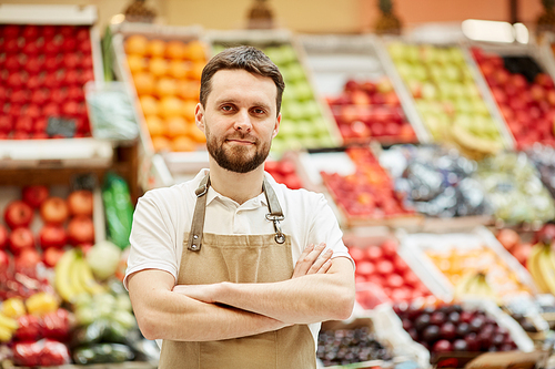 waist up portrait of bearded man  while standing by fruit and  stand at farmers market, copy space