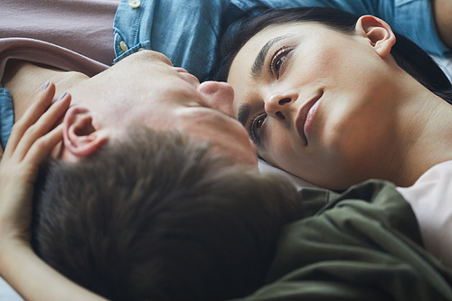 Close up of loving couple embracing tenderly while lying together, copy space