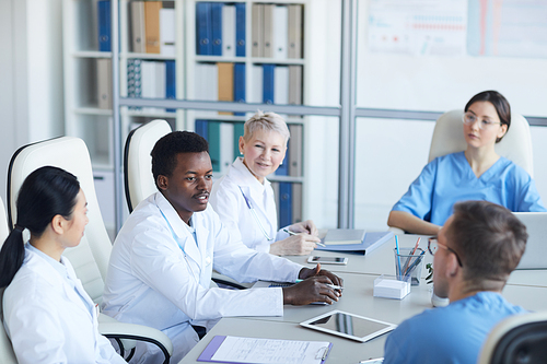 High angle view at young African-American doctor speaking during medical conference and smiling happily, copy space