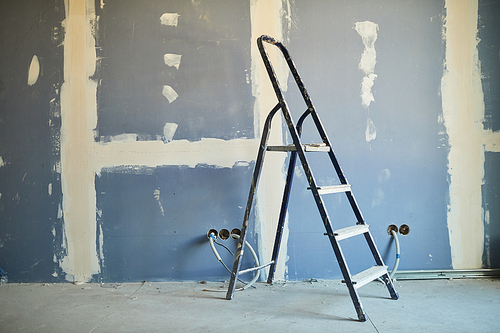 Background image of used ladder against dry wall on construction site or building house, copy space
