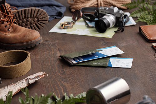 Close-up of hiking things and passports with airline tickets for foreign adventure on wooden table