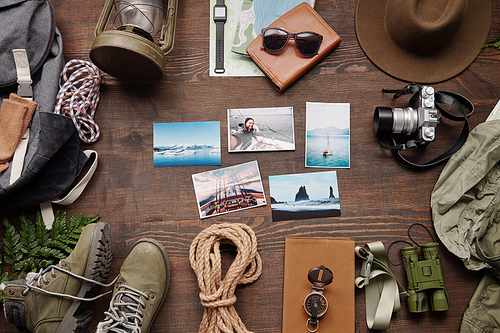 Adventure photos, photographic camera, clothes and backpack on table of traveler, flat lay