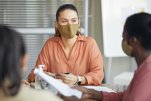 Portrait of modern businesswoman wearing mask while heading business meeting in office, copy space