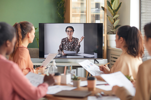 Portrait of smiling businesswoman on computer screen talking to team during online business meeting, copy space