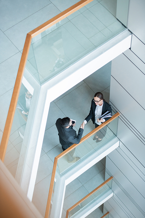 Directly above view of businessman with tablet greeting new specialist in company