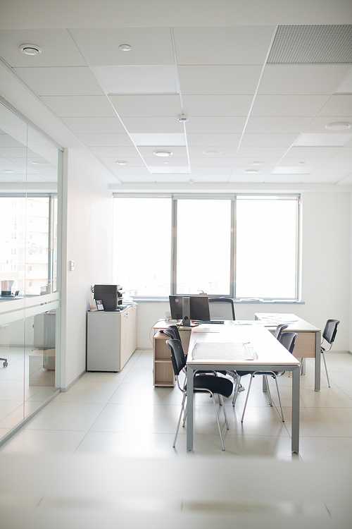 Contemporary interior of empty office room with long table, chairs and desk with computer