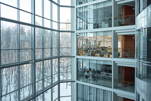 Several floors of large contemporary business center with open space offices, windows, balconies and elevator between them